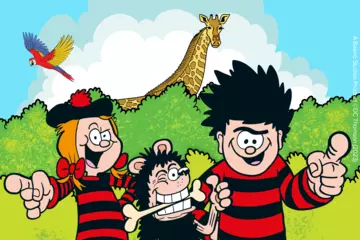 Dennis Menace, Gnasher and Minnie are pointing and displaying thumbs up to the viewer in the foreground, while in the background is a double hedge line in shades of green, a giraffe and a parrot in front of a blue sky background