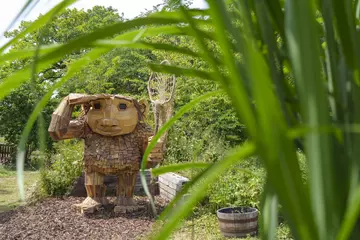 Image of a wooden troll that is part of the Trolls: A Field Study event at Whipsnade Zoo
