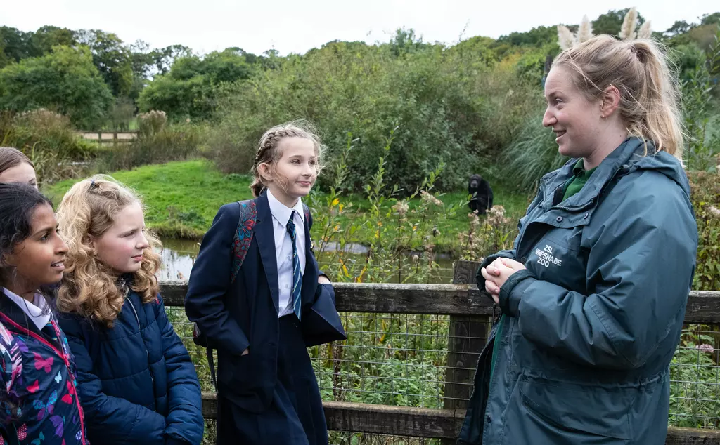 A Whipsnade Zoo presenter with a four teenage school children
