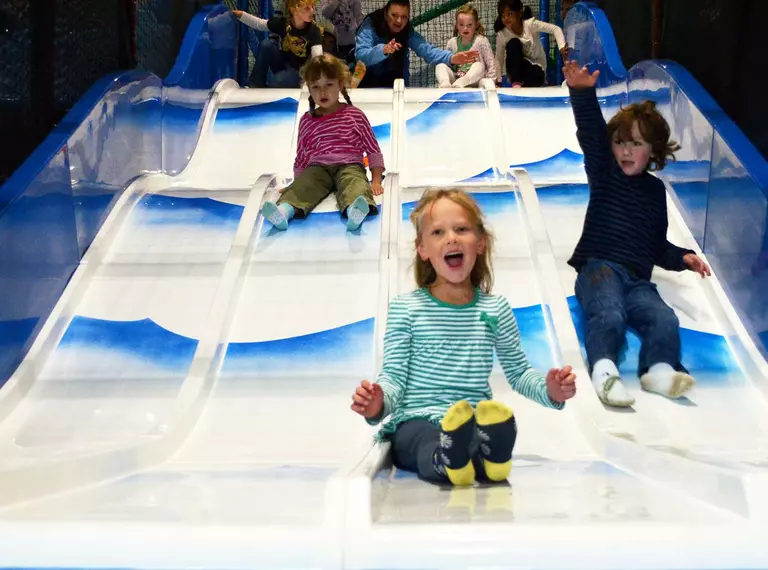 Children on a slide Hullabazoo children's indoor play area