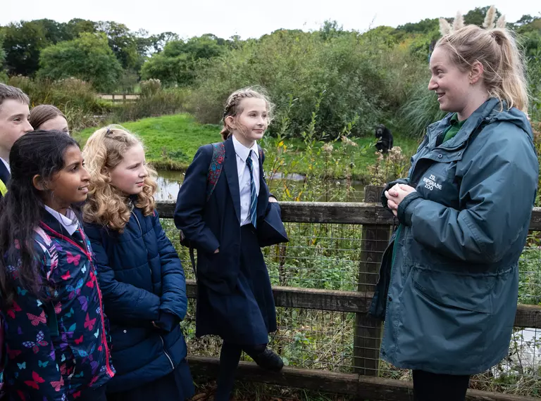 A Whipsnade Zoo presenter with a group of teenage school children