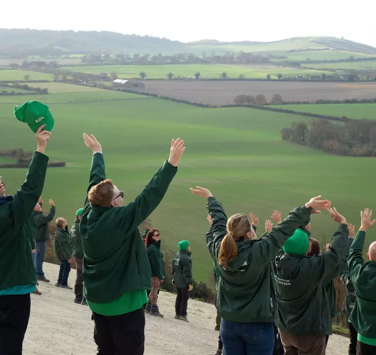 Volunteers waving on white lion